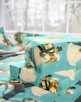 1960s inspirited wrapping paper featuring a retro bride and groom in winter wedding wear on a turquoise background