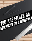 Bumper sticker with political text on a black surface with stationery items