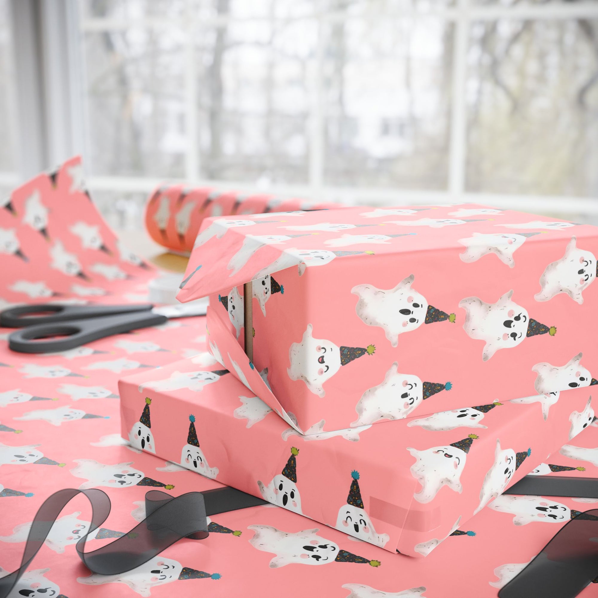 Birthday ghost wrapping paper featuring white ghosts with party hats on coral pink background