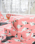 Birthday ghost wrapping paper featuring white ghosts with party hats on coral pink background