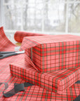 Red plaid gift wrap with scissors on a matching surface