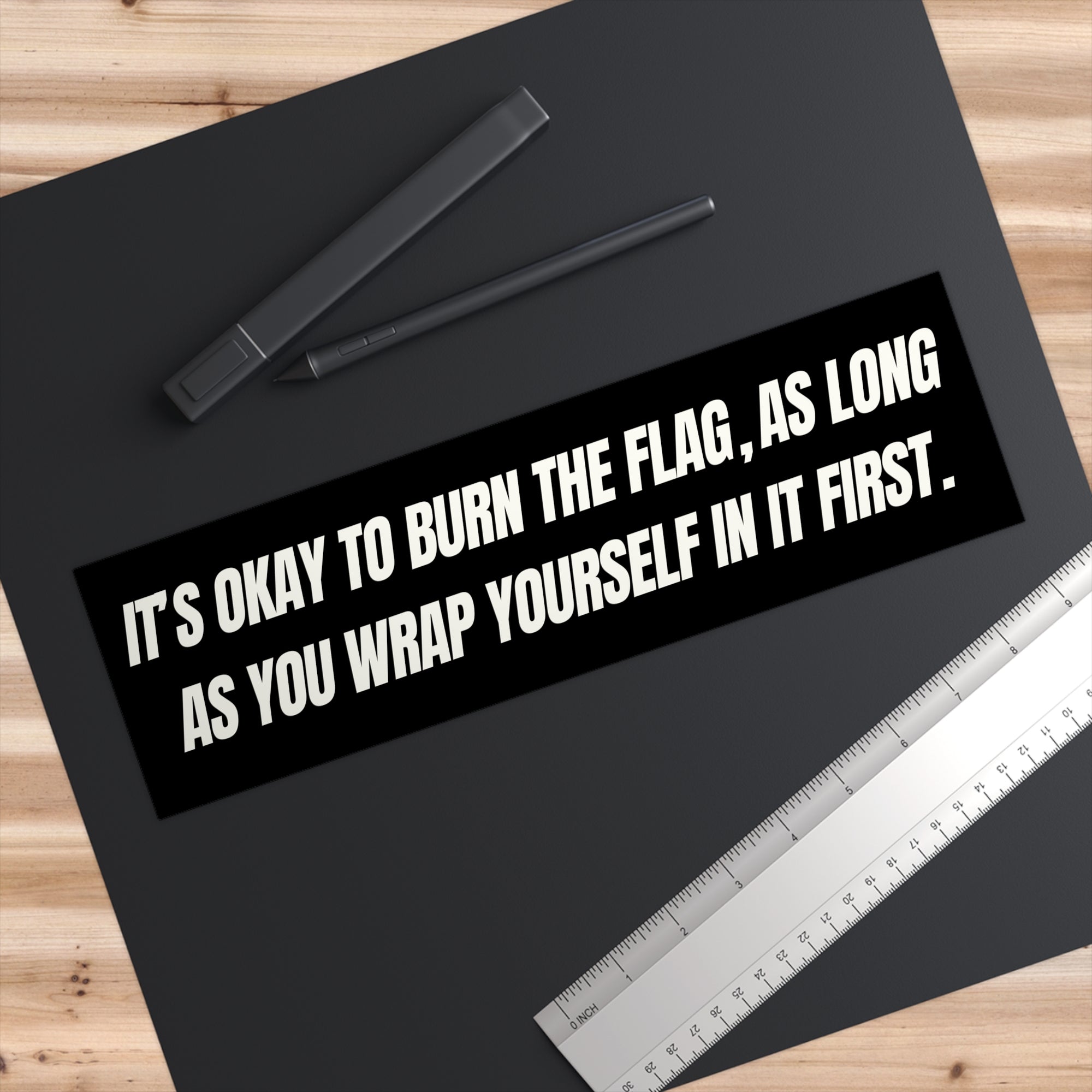 Black mat with text and stationery items on a wooden surface