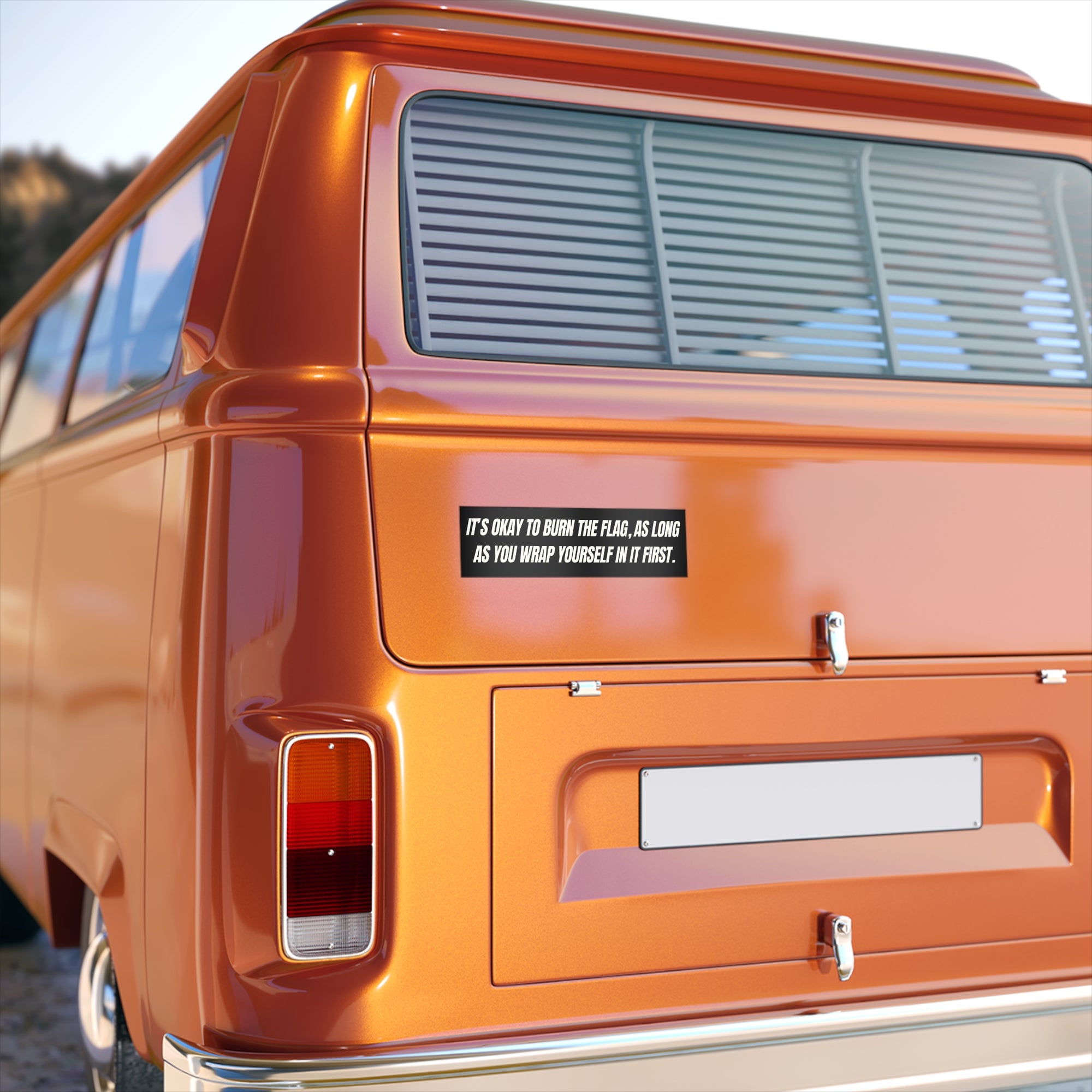 Orange van with a humorous sticker on the back window.