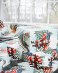 Christmas-themed gift wrap with a very patriotic Santa Claus and American flag with snowy trees in the background.