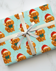 Gift wrapped in Christmas themed wrapping paper featuring a fluffy Pomeranian in a Santa hat and teal bow.