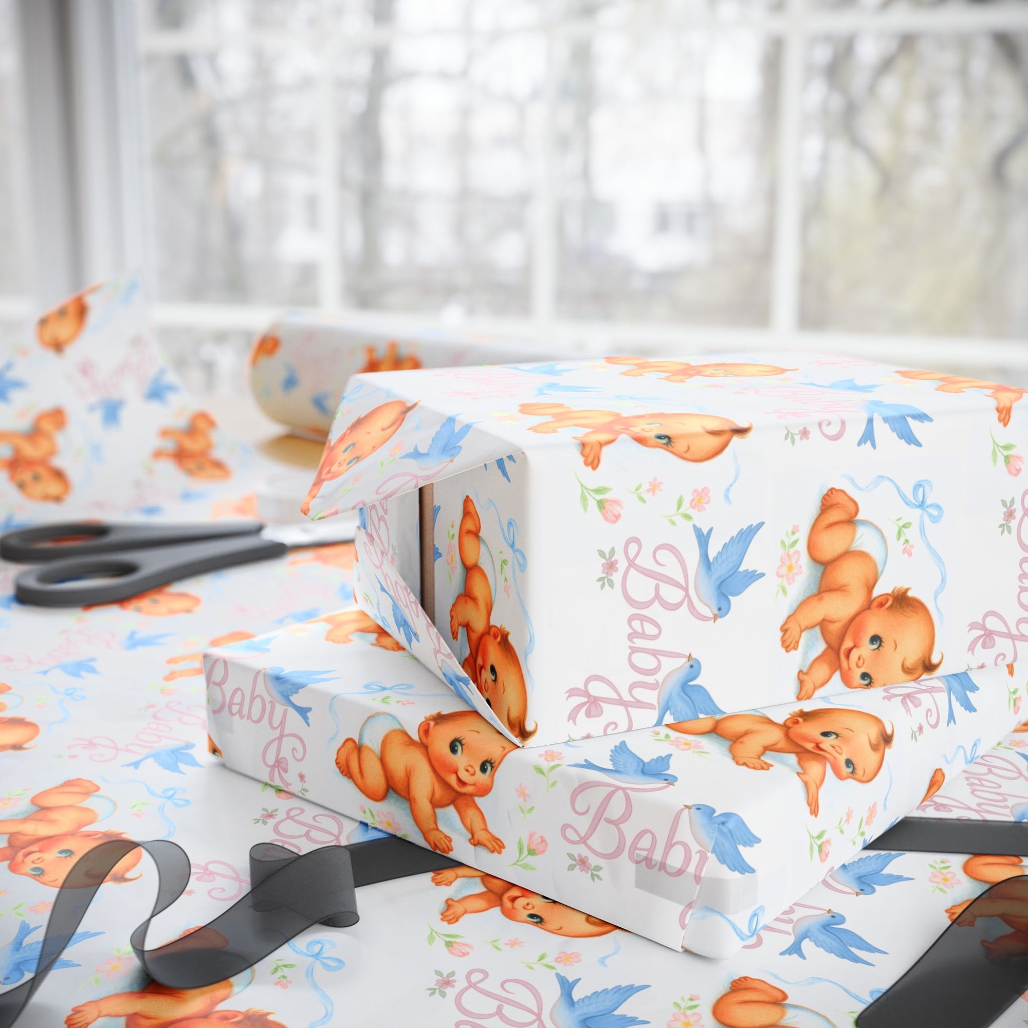 Gift box wrapped in baby-themed paper with scissors on a matching surface