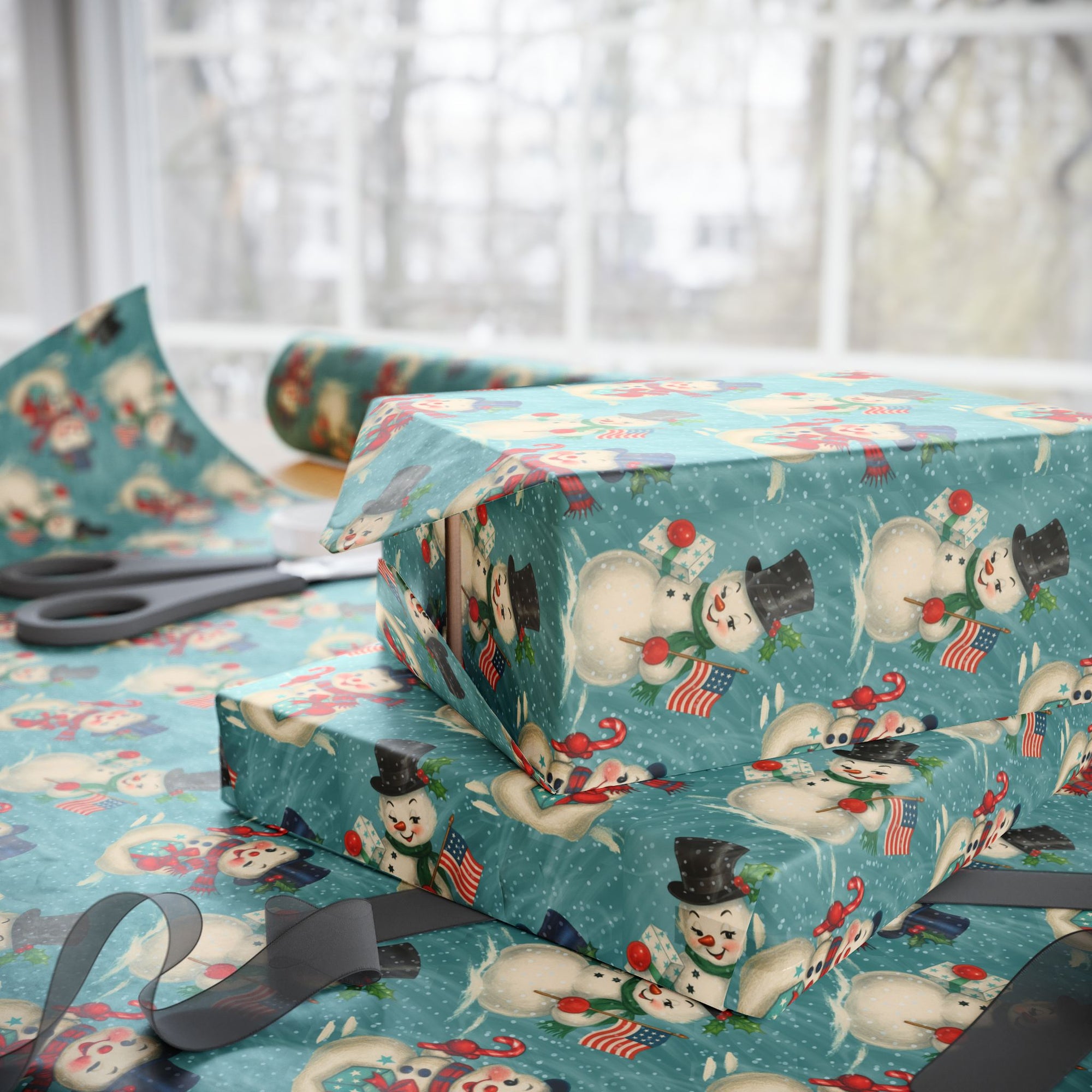 Stack of wrapped presents with snowman pattern on a table with scissors.
