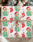 gifts wrapped in babys first christmas wrapping paper that has a sweet bunny and a little brunette baby boy in a santa cap.