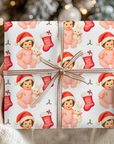 christmas gift wrapped in babys first christmas wrapping paper with a brunette baby with a little bunny.