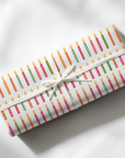 roll of wrapping paper featuring birthday candles in every color.