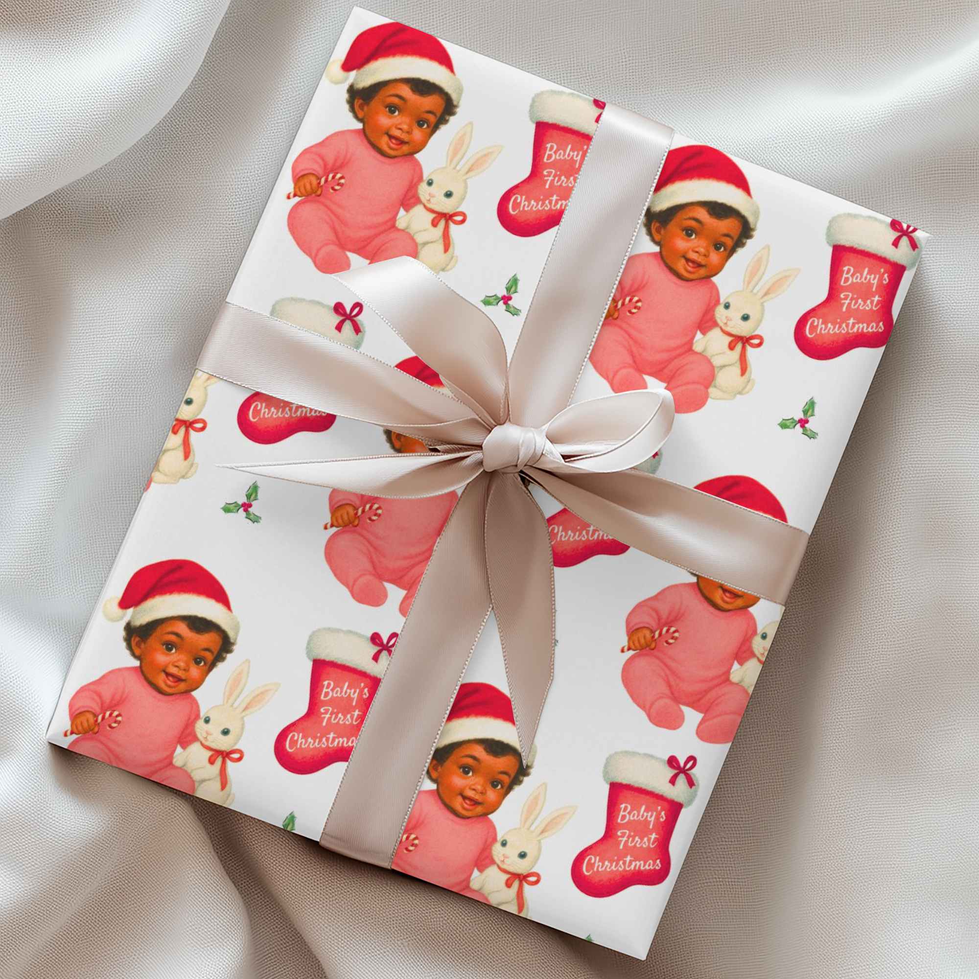 Vintage “Baby’s First Christmas” wrapping paper featuring a smiling dark-skinned baby girl in a pink romper and Santa hat holding a white bunny plush and candy cane, surrounded by red Christmas stockings and holly, retro storybook illustration style.