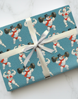 Funny retro fitness snowman wrapping paper with bodybuilder and snowman lifting weights on snowy blue background.