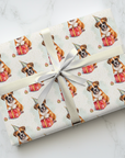 Birthday gift wrapped in paper with a boxer dog illustration with party hat and presents.