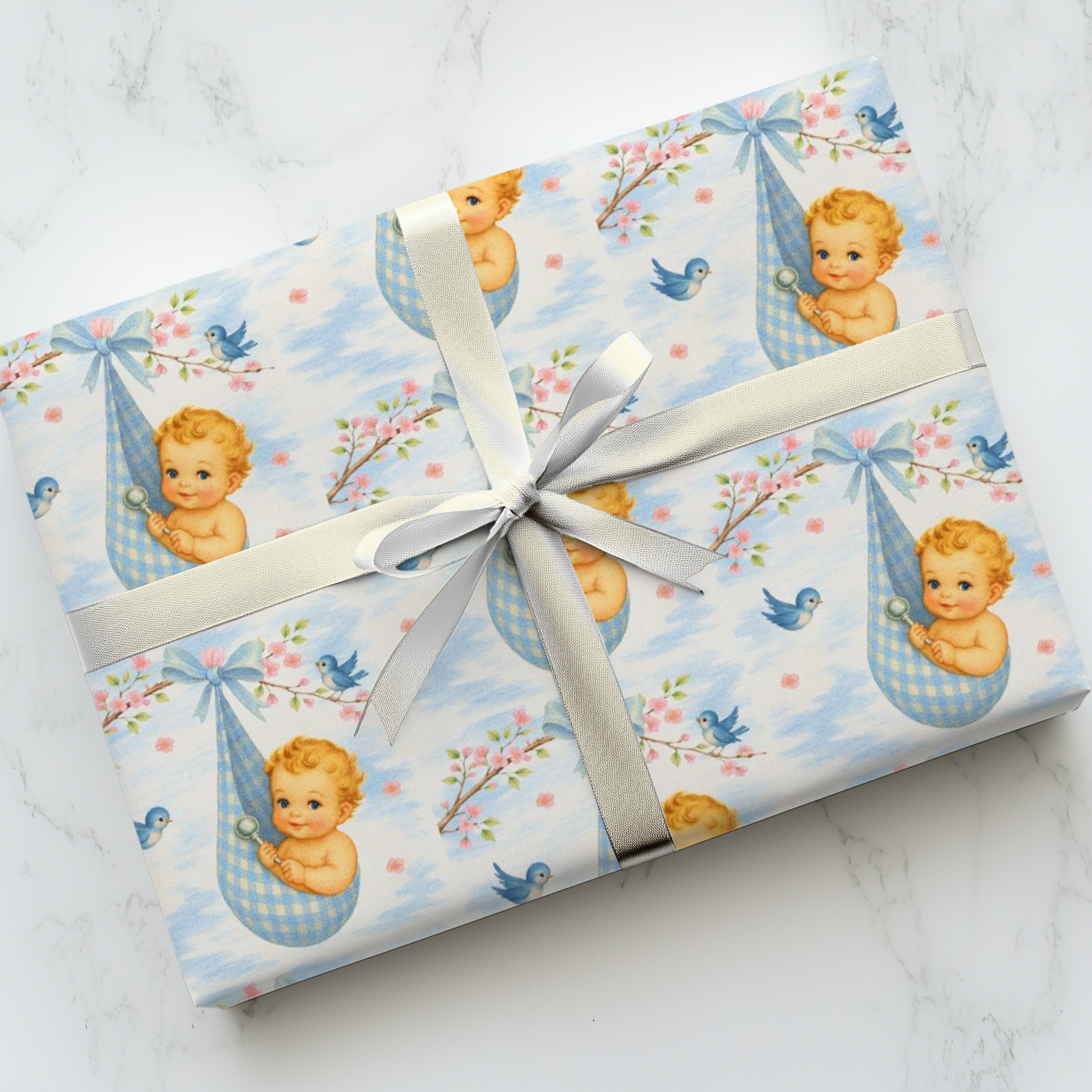 Gift wrapped in baby-themed paper with a white ribbon on a marble surface