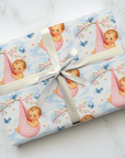 Gift wrapped in baby and cherry blossom designed paper with a ribbon on a marble surface