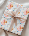 Gift wrapped in baby and cherry blossom wrapping paper with a bow on a soft surface
