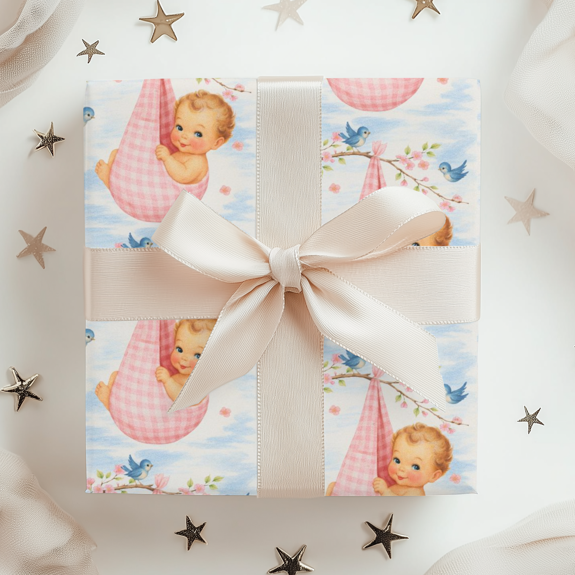 Gift box with baby-themed wrapping paper and a pink bow, surrounded by decorative stars.