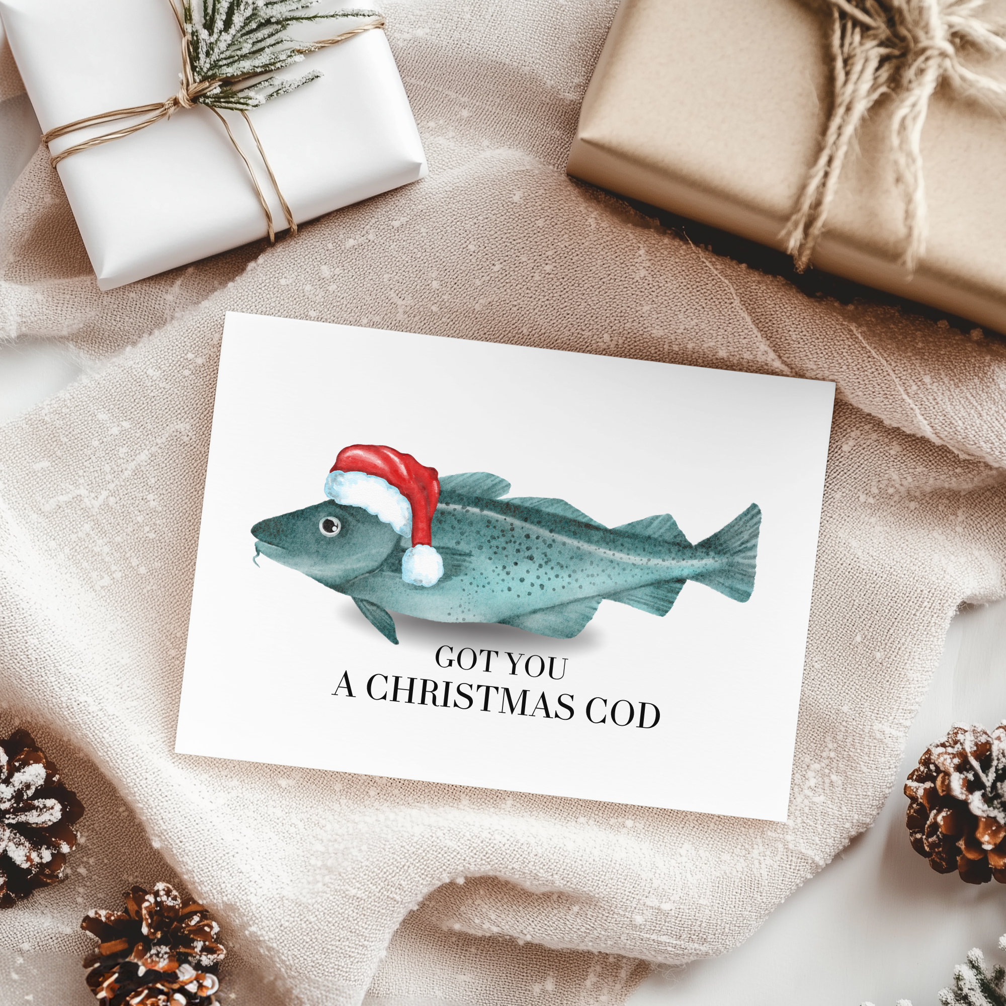 Card with fish wearing a Santa hat and text 'GOT YOU A CHRISTMAS COD' on a festive background with wrapped gifts and pinecones.