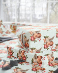 Gift wrap with cherub and floral design on a table with scissors.