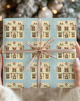 Whimsical Christmas dollhouse pattern with garlands and golden stars on dusty blue gift wrap.