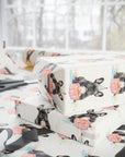 Gift boxes wrapped in paper with a french bulldog pattern on a table with scissors.