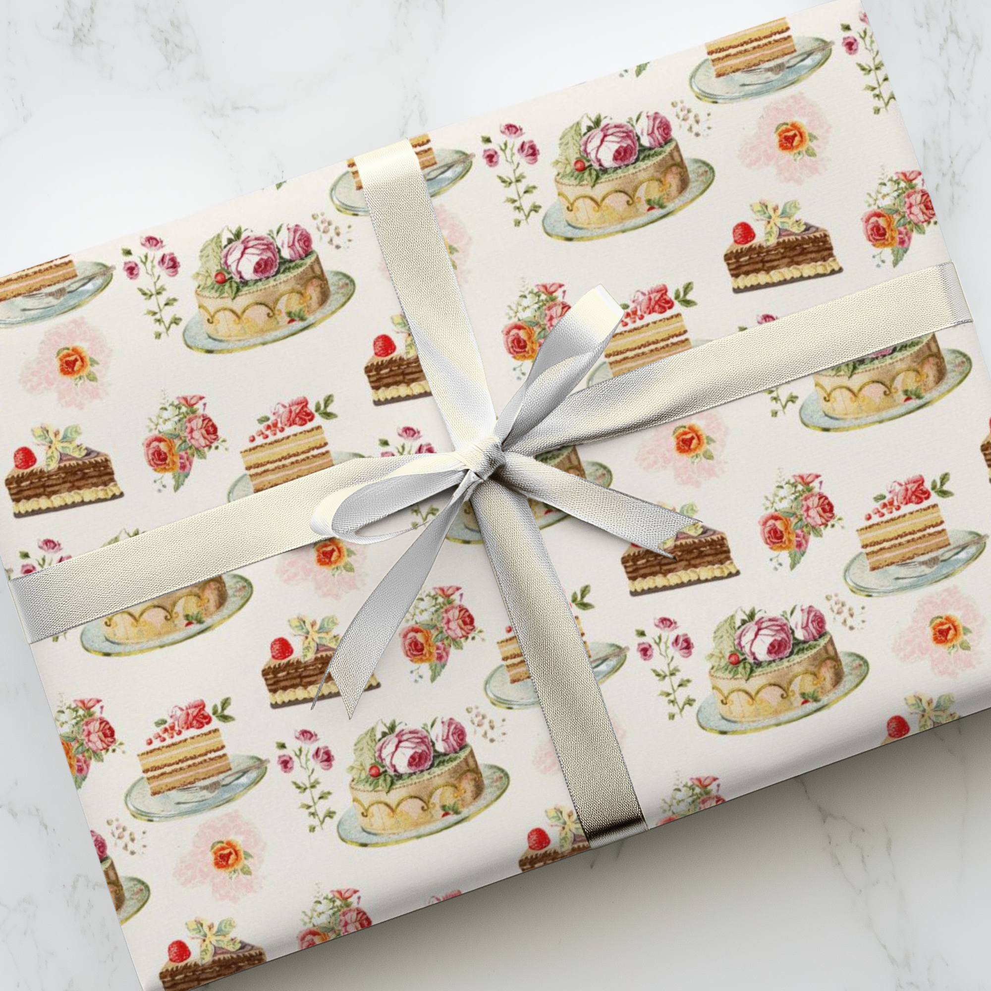 Gift wrapped in paper with cake pattern on a marble surface.