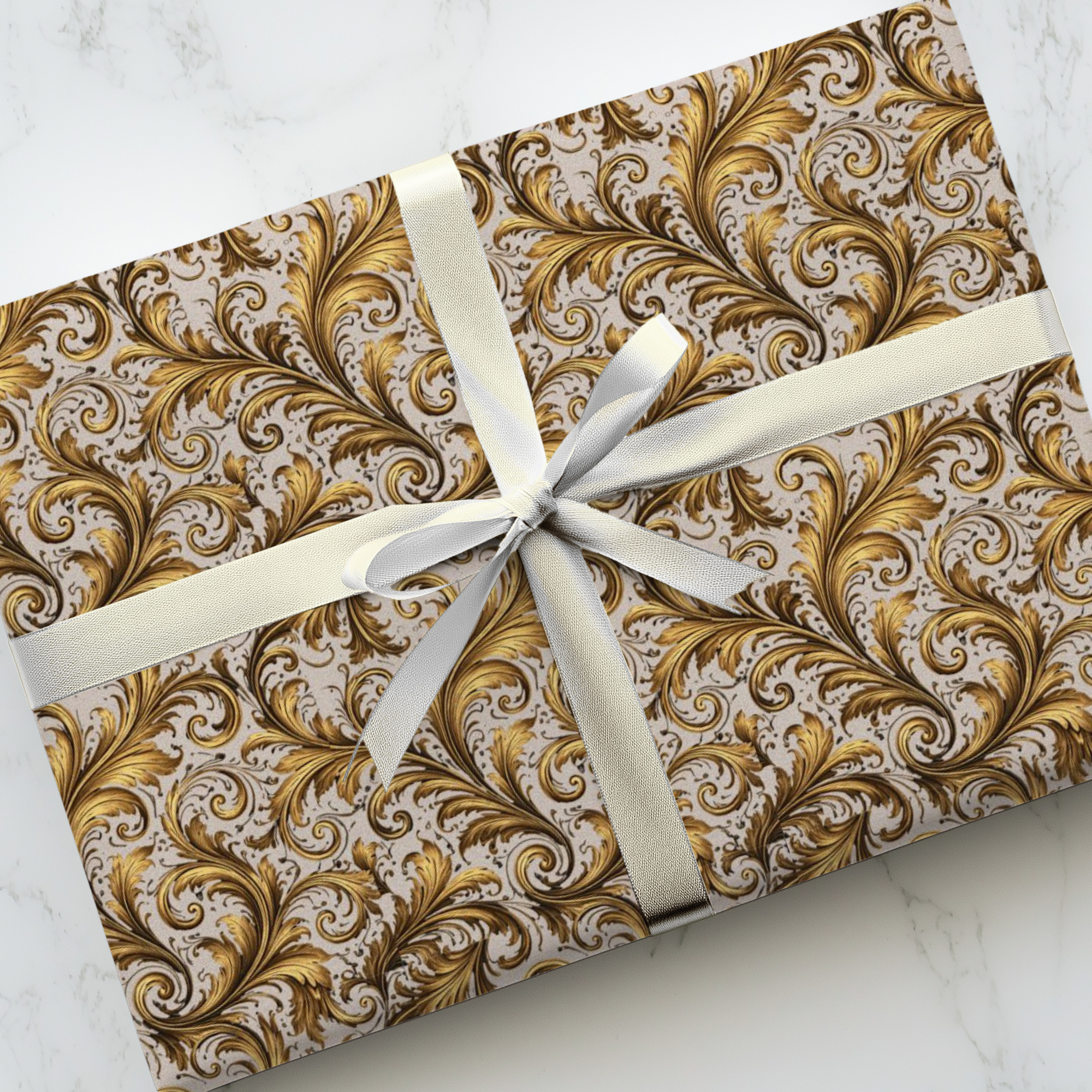 Gift box with gold and gray pattern and white ribbon on a marble surface