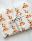 Birthday gift wrapped in paper with a pattern of golden retriever puppies in party hats with presents.
