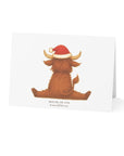 Card with a highland bull wearing a Santa hat on a white background