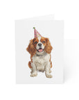 King Charles Cavalier dog wearing a party hat on a white birthday card