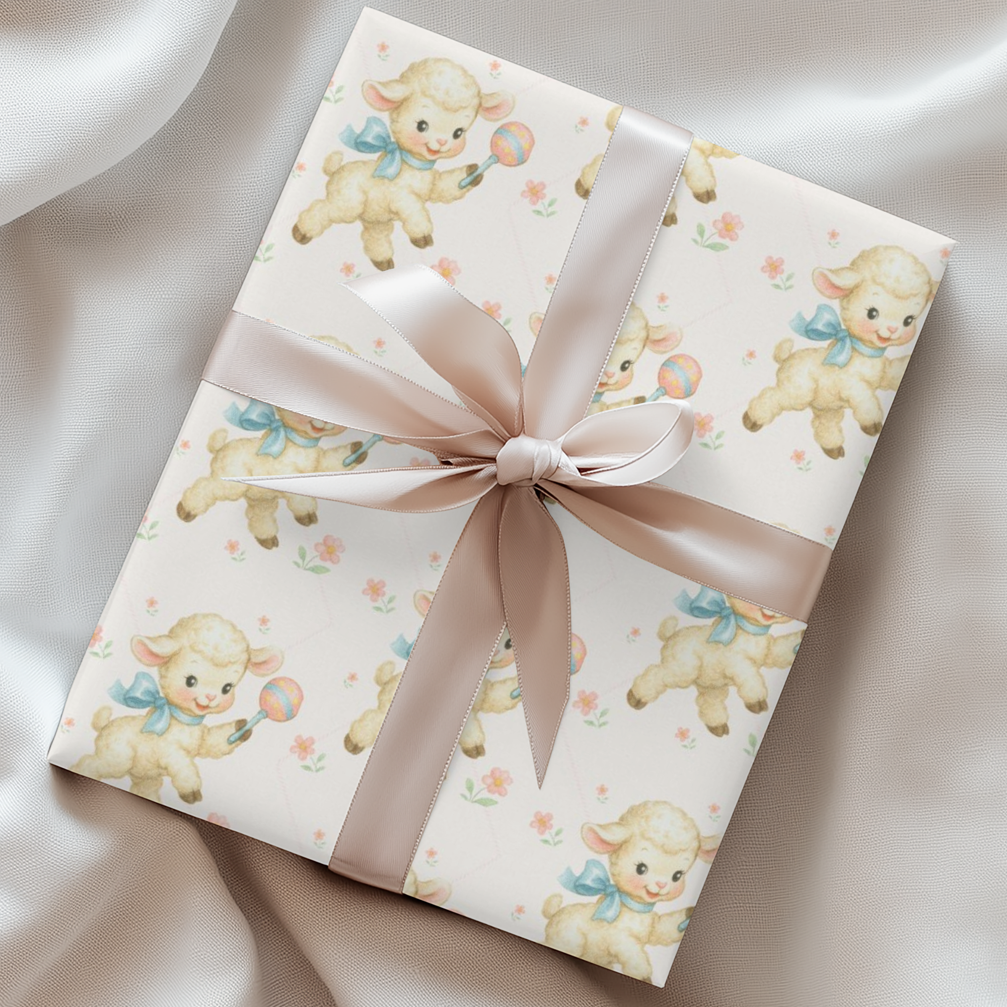 Gift wrapped in paper with lamb design and pink ribbon on a satin surface