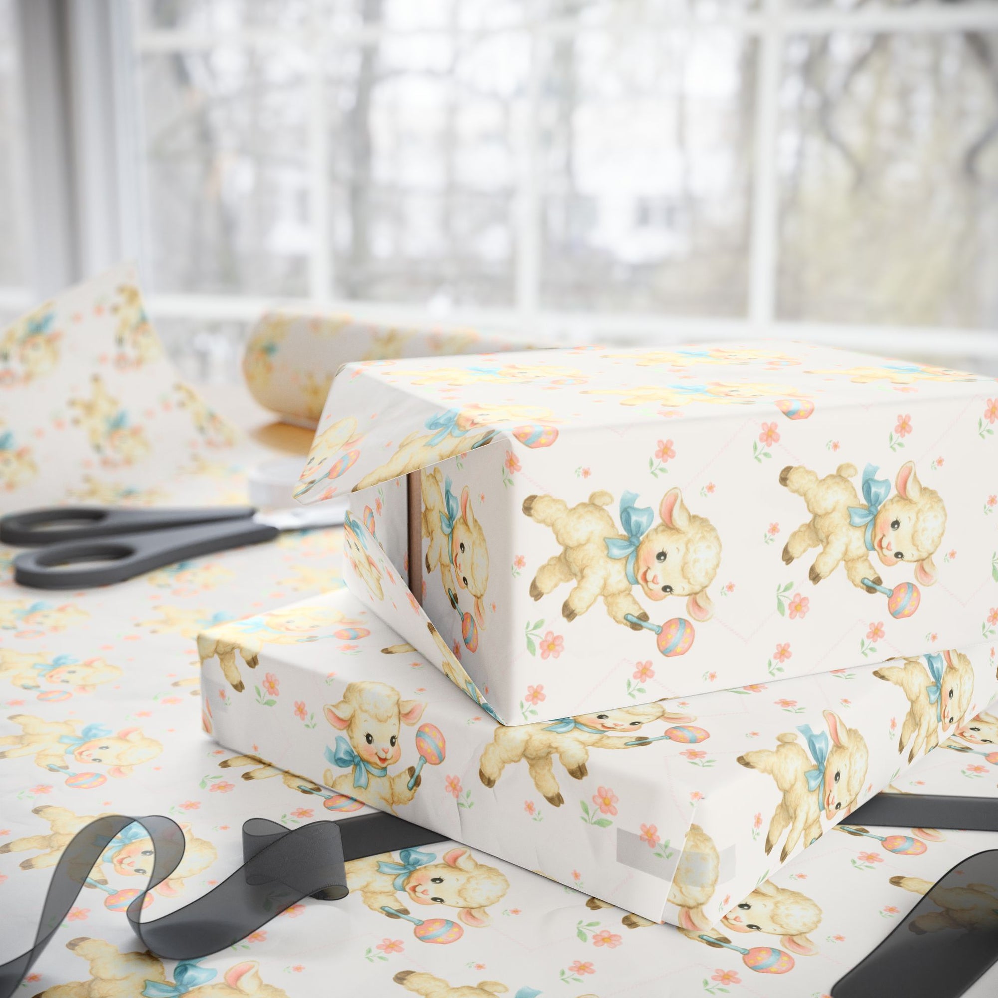 Gift boxes with baby-themed wrapping paper and scissors on a white surface.