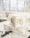 Gift boxes with baby-themed wrapping paper and scissors on a white surface.