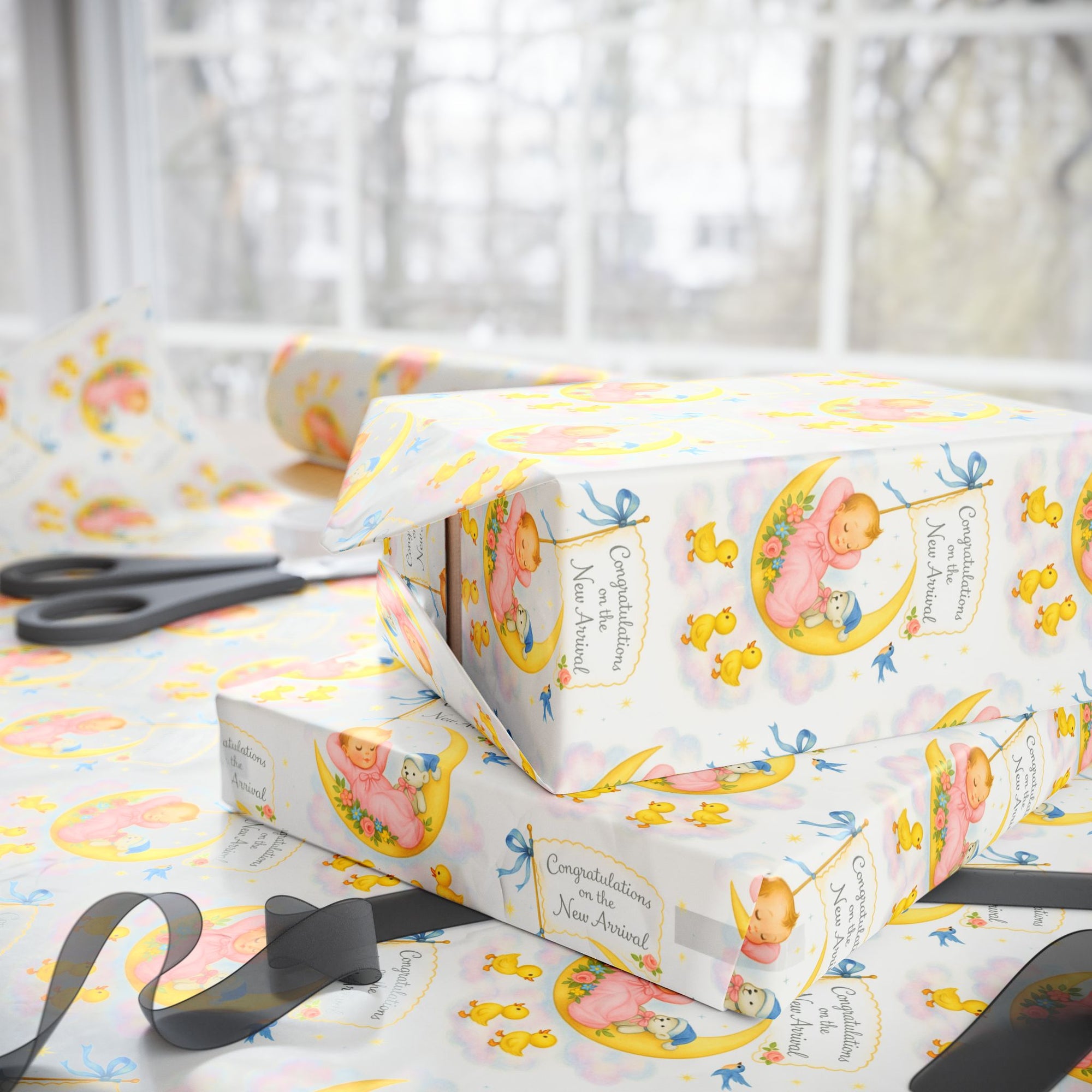 Gift boxes wrapped in baby-themed wrapping paper in sweet pastels.