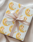 Gift wrapped in paper with baby illustrations and a pink ribbon on a soft background