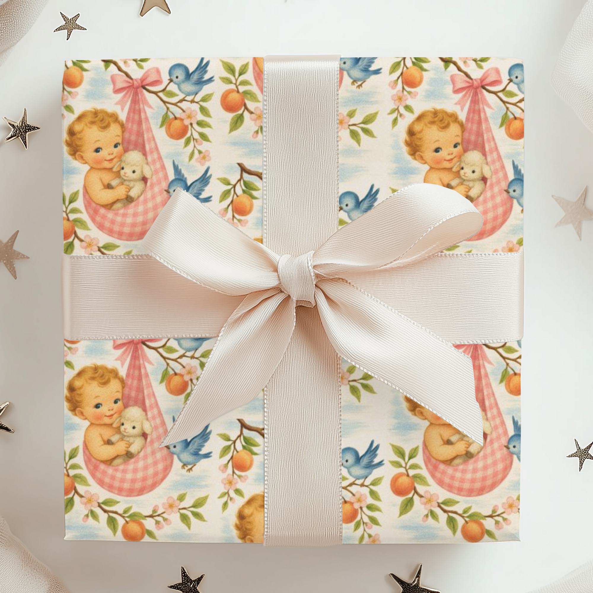 Gift box with baby-themed wrapping paper and a white ribbon on a white background with star decorations.
