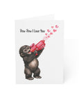 Card with a monkey holding a red gun shooting hearts, text 'Pew Pew I Love You' on a white background.