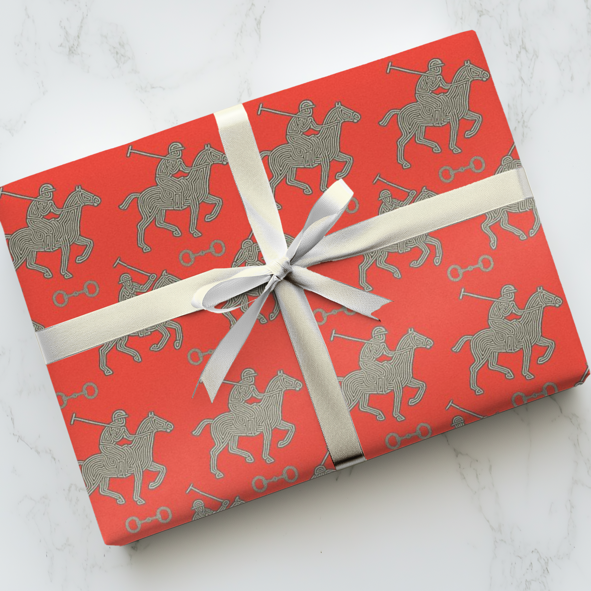 Red wrapping paper featuring silver polo players in a horse and rider pattern.