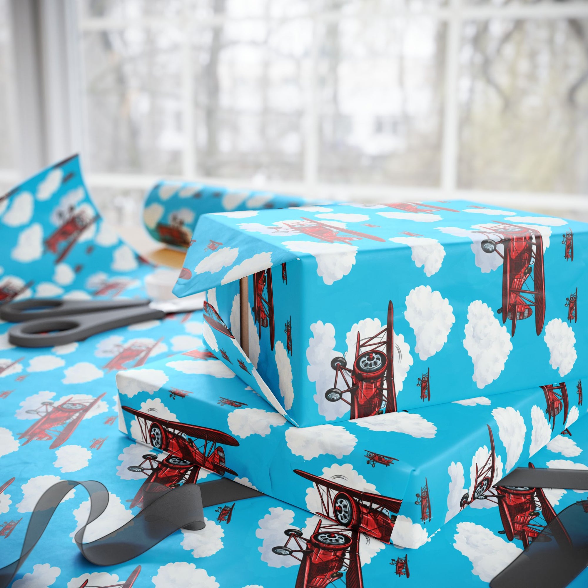 Wrapping paper with a pattern of red biplanes flying through a blue sky with white clouds.