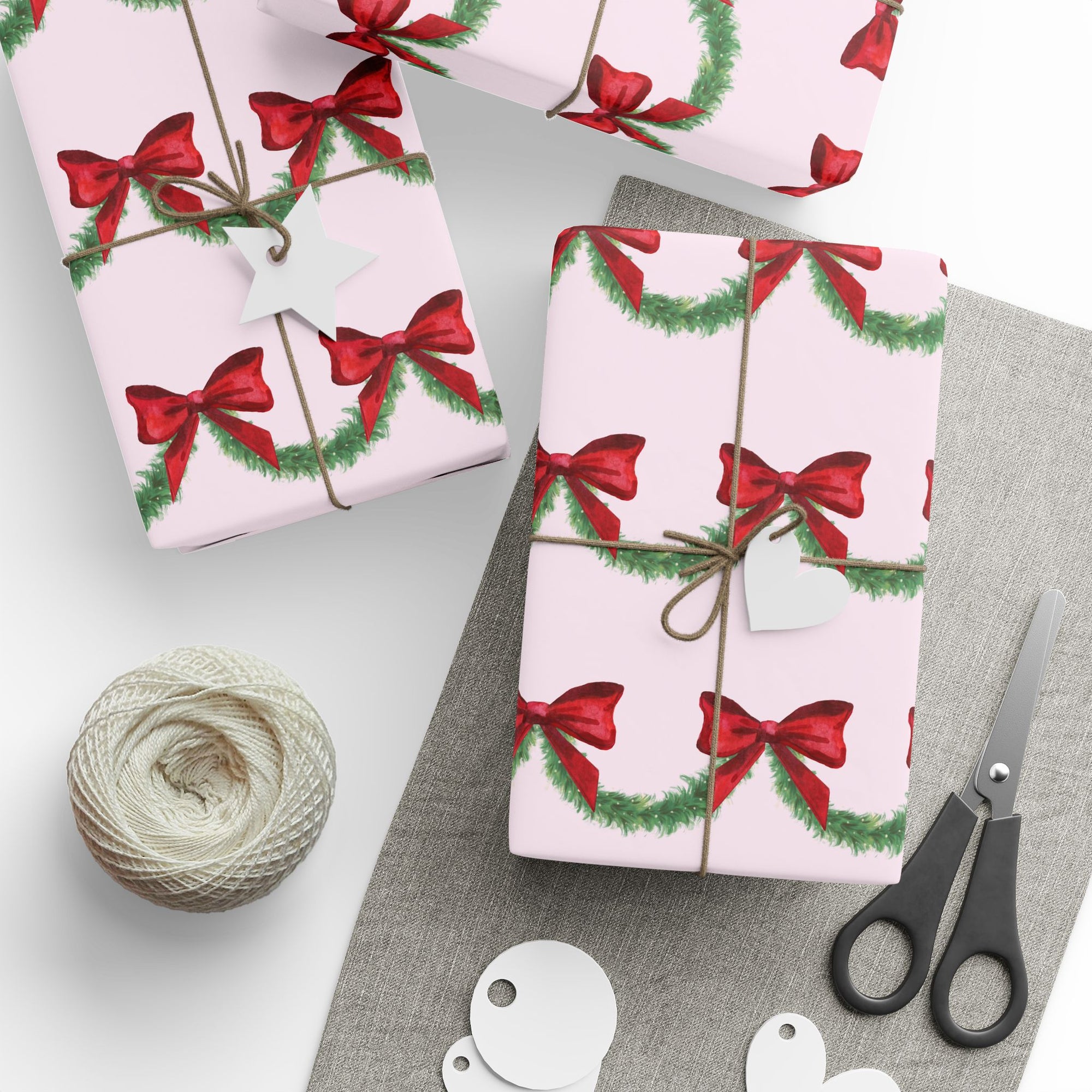 Christmas-themed wrapping paper with red bows and green garland on a pink background front