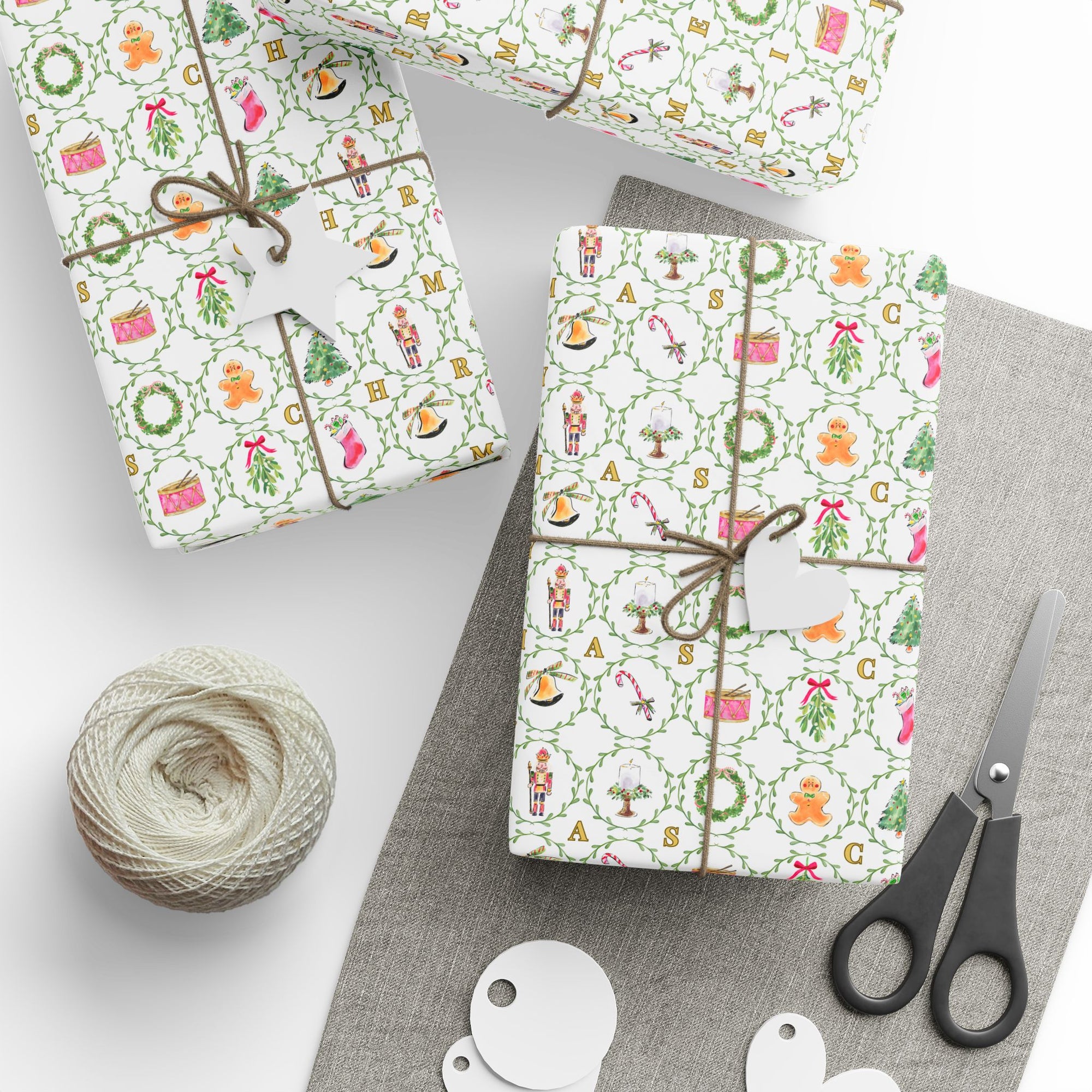 Gift boxes wrapped in festive paper with a ball of yarn and scissors on a gray surface.