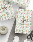 Gift boxes wrapped in festive paper with a ball of yarn and scissors on a gray surface.