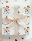 Gift box with cowboy baby, horseshoes and rocking horse pattern on a light background.