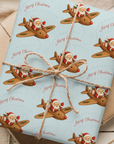 Gift wrapped in Christmas-themed paper with Santa Claus and reindeer design.