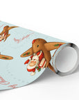 Roll of Christmas-themed paper with gingerbread men and Santa Claus on a light blue background.