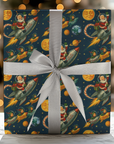 Vintage-style Christmas wrapping paper featuring Santa flying a rocket among planets and stars with mid-century retro colors.