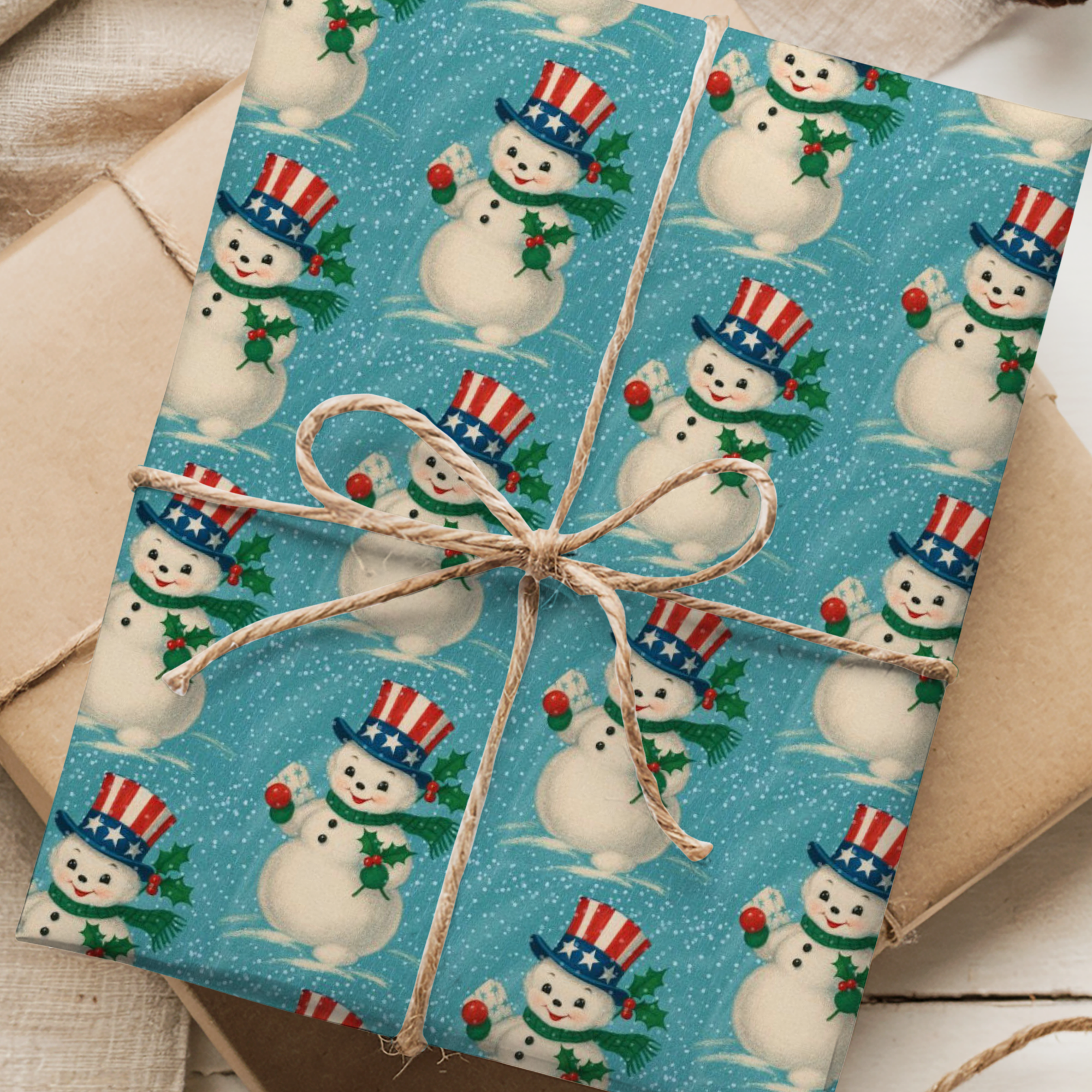 Gift wrapped in blue paper with snowman pattern, tied with brown string on a wooden surface.