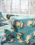 Uncle Sam snowman wrapping paper with Patriotic hats and holly on teal snowy background.