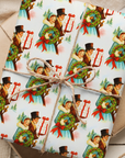 Vintage Victorian Christmas wrapping paper featuring carolers holding a wreath and gift against snowy pine background.