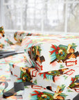 Vintage Victorian Christmas wrapping paper featuring carolers holding a wreath and gift against snowy pine background.
